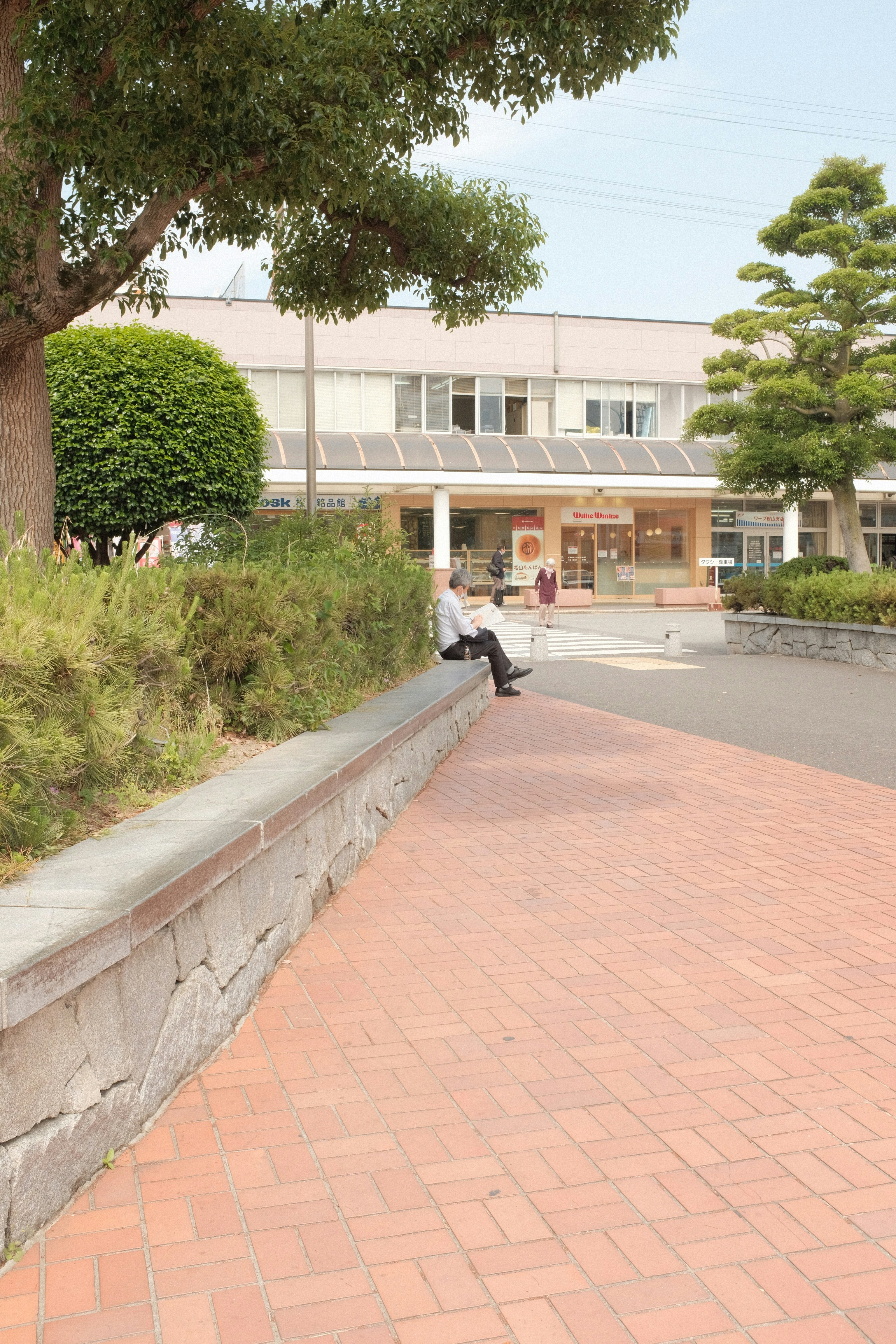 man in black jacket walking on sidewalk during daytime